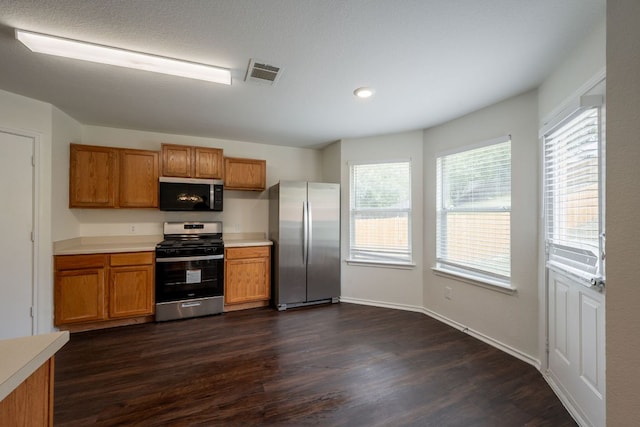 292 Dandelion Loop, Kyle, TX 78640 - kitchen featuring appliances with stainless steel finishes, brown cabinets, dark wood-style floors, light countertops, and recessed lighting