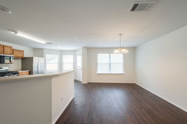 292 Dandelion Loop, Kyle, TX 78640 - kitchen with appliances with stainless steel finishes, baseboards, dark wood-type flooring, a chandelier, and light countertops