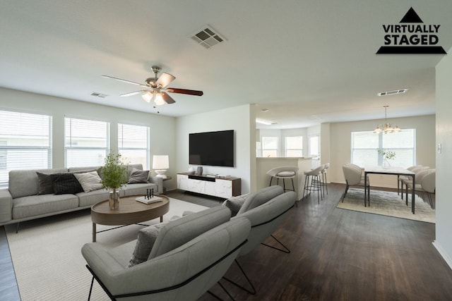 292 Dandelion Loop, Kyle, TX 78640 - living room featuring dark wood-type flooring, a chandelier, a ceiling fan, and baseboards