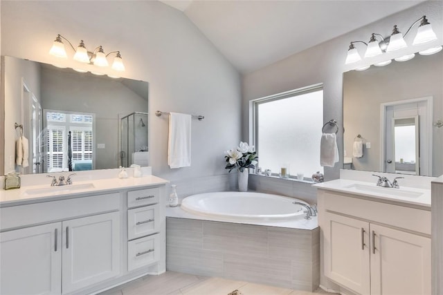full bath with a sink, a shower stall, a garden tub, and lofted ceiling