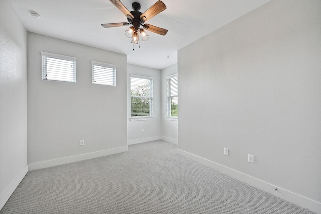 spare room featuring carpet floors, ceiling fan, and baseboards