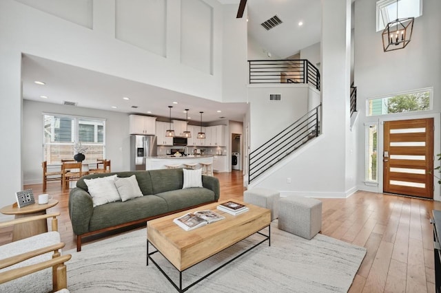 living area with visible vents, stairs, and a high ceiling