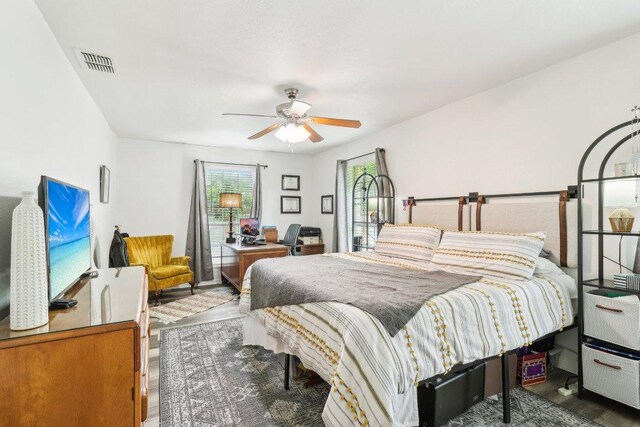 bedroom featuring ceiling fan, visible vents, and wood finished floors