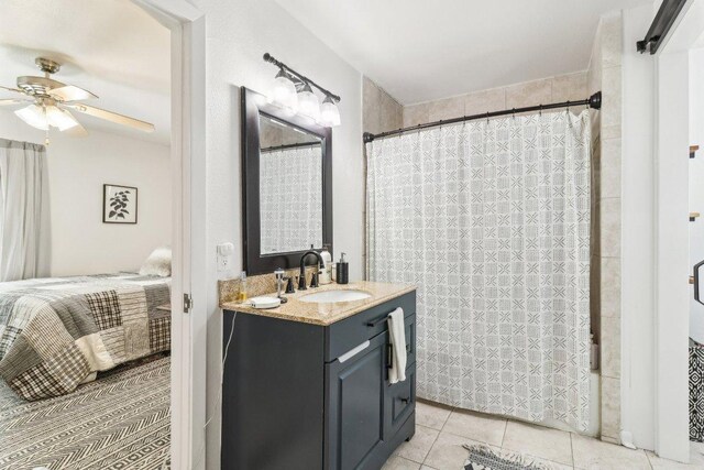 bathroom featuring vanity, tile patterned flooring, shower / bath combo with shower curtain, and a ceiling fan