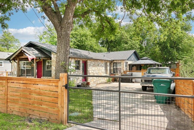 single story home with a gate, fence private yard, and stone siding