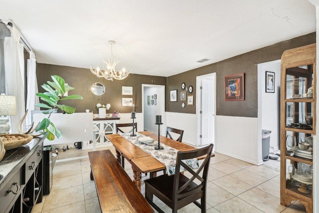 421 James St, Boerne, TX 78006 - dining space featuring a chandelier, wainscoting, and light tile patterned floors