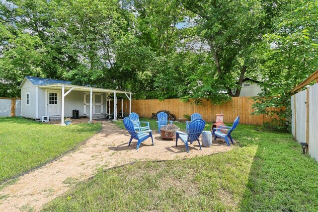 view of yard featuring a fenced backyard and a fire pit