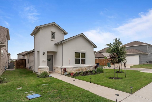 view of front facade featuring fence, stucco siding, driveway, and a front yard