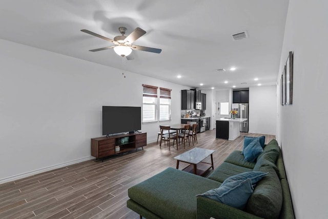 living room with baseboards, ceiling fan, dark wood-style floors, and visible vents