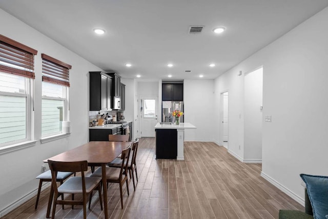 dining room featuring visible vents, a wealth of natural light, and light wood-type flooring