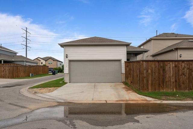 garage with fence and driveway