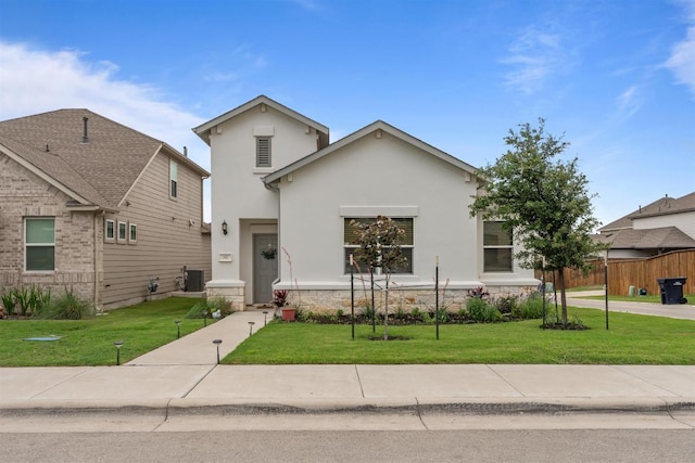 view of front of property featuring stucco siding, central AC, and a front lawn
