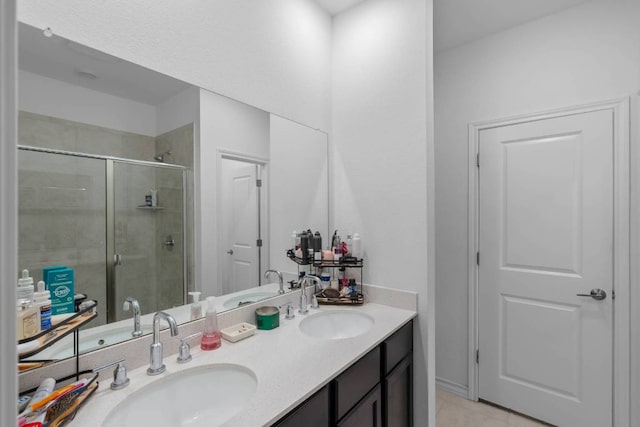 bathroom featuring a sink, a shower stall, and double vanity