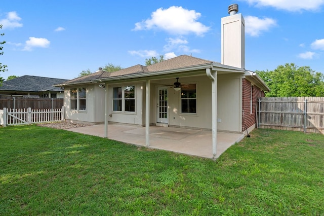back of property with a fenced backyard, a ceiling fan, a chimney, and a lawn