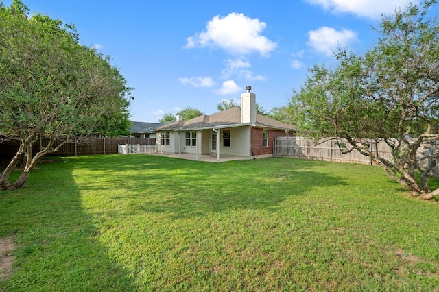 back of house with a lawn, a fenced backyard, and a patio area