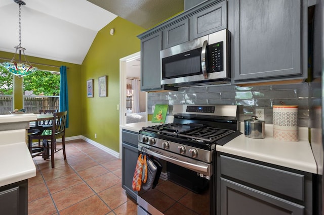 kitchen with light countertops, appliances with stainless steel finishes, lofted ceiling, and tasteful backsplash