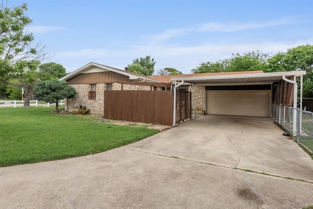 view of home's exterior featuring driveway, a garage, fence, a yard, and stone siding