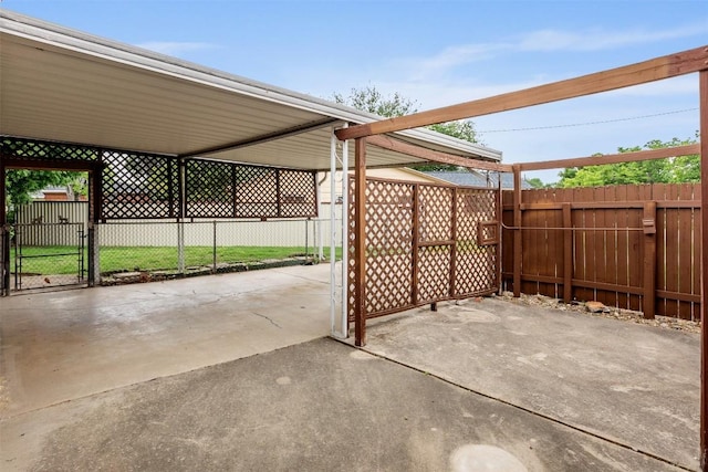 view of patio with fence, a gate, and a carport
