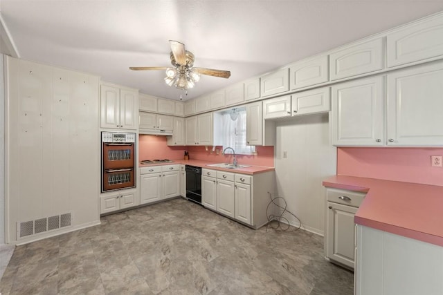 kitchen with visible vents, black dishwasher, multiple ovens, stovetop, and a sink