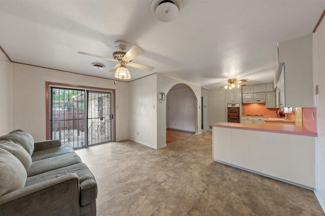 living room with visible vents, a ceiling fan, and arched walkways