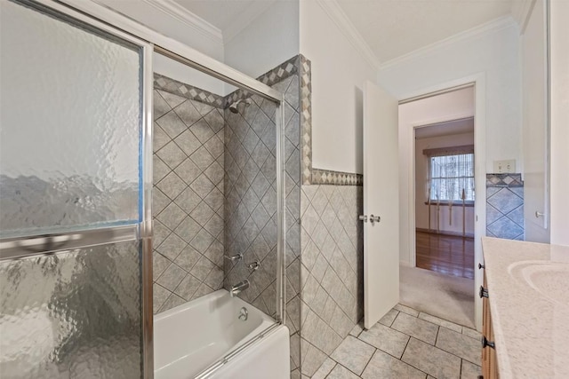 bathroom featuring crown molding, tile walls, tile patterned floors, vanity, and enclosed tub / shower combo