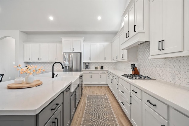 kitchen with light countertops, stainless steel appliances, white cabinets, and gray cabinets