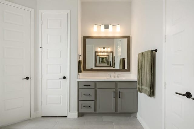 bathroom featuring baseboards, tile patterned flooring, and vanity
