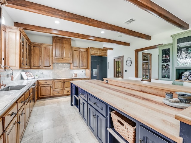 kitchen featuring a sink, visible vents, wooden counters, and built in fridge