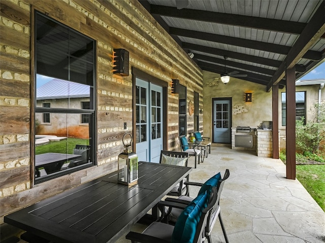 view of patio / terrace featuring an outdoor kitchen, a ceiling fan, and outdoor dining space