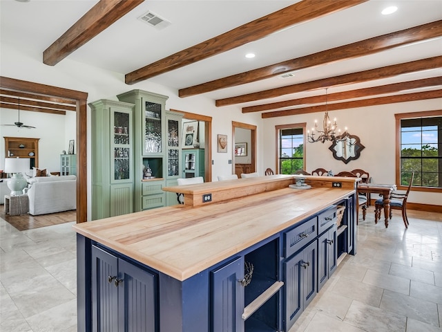 kitchen with visible vents, pendant lighting, butcher block countertops, a chandelier, and blue cabinets