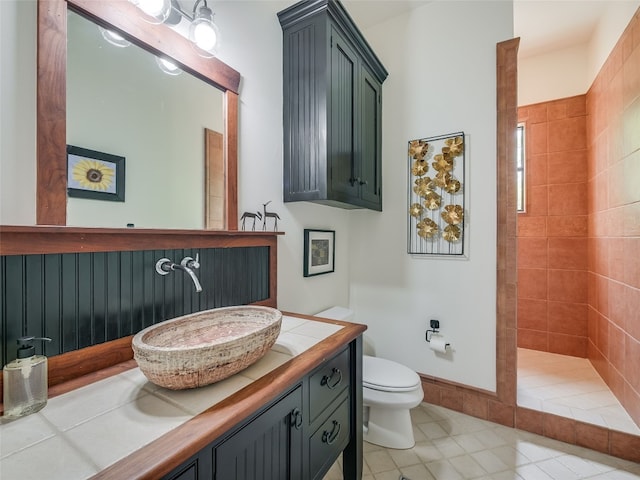 bathroom with vanity, a tile shower, and toilet