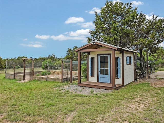 view of outbuilding featuring fence, an outbuilding, and a vegetable garden