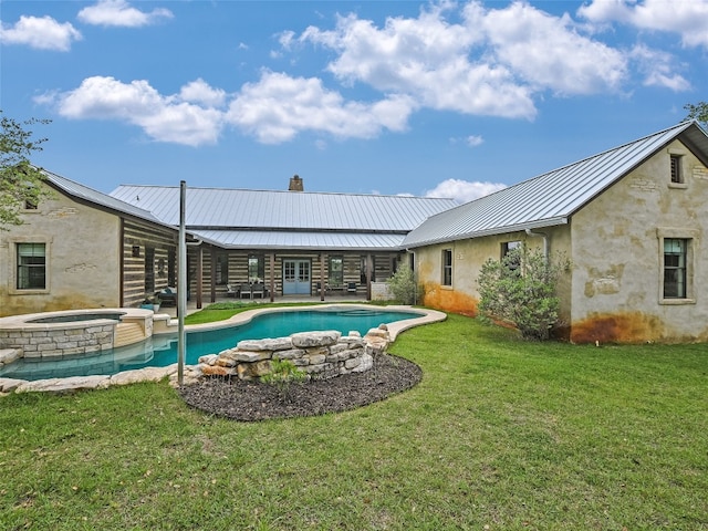 back of property with a standing seam roof, a chimney, a lawn, and metal roof