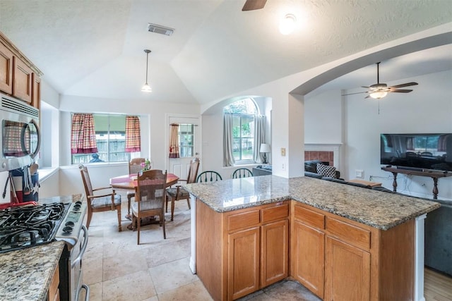 kitchen featuring visible vents, arched walkways, a ceiling fan, appliances with stainless steel finishes, and vaulted ceiling