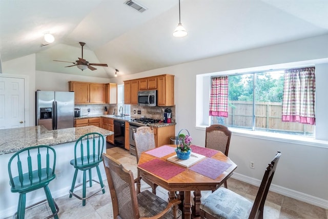 dining space featuring a ceiling fan, baseboards, visible vents, and lofted ceiling