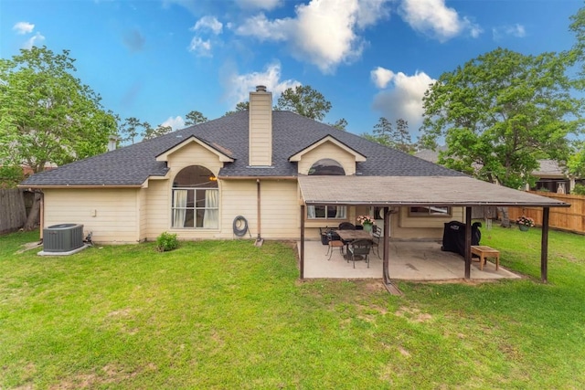 rear view of house with a chimney, a lawn, central AC unit, a patio area, and fence