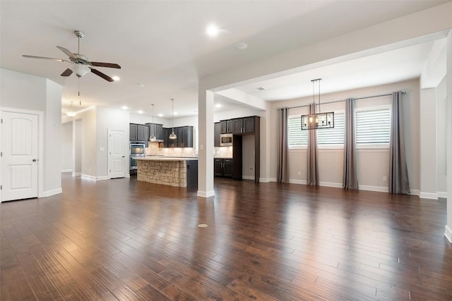 103 Lockhart Loop, Georgetown, TX 78628 - unfurnished living room featuring a ceiling fan, dark wood finished floors, a chandelier, and recessed lighting