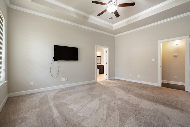 103 Lockhart Loop, Georgetown, TX 78628 - unfurnished bedroom featuring a tray ceiling, carpet floors, crown molding, ensuite bath, and ceiling fan