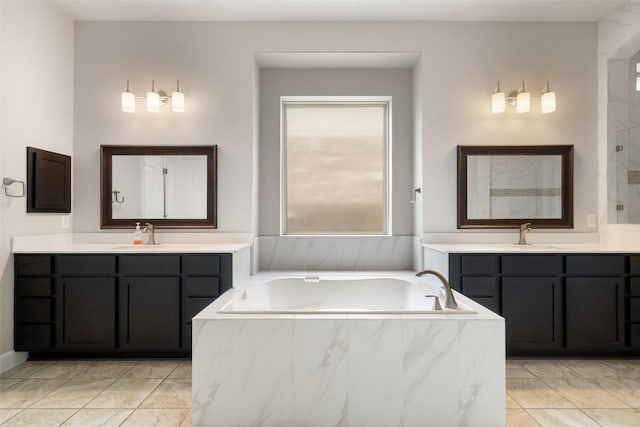 103 Lockhart Loop, Georgetown, TX 78628 - full bath with two vanities, a garden tub, marble finish flooring, and a shower