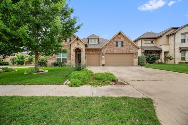 103 Lockhart Loop, Georgetown, TX 78628 - traditional-style home featuring an attached garage, concrete driveway, a front lawn, brick siding, and stone siding