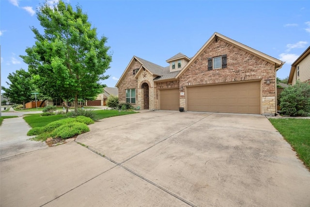 103 Lockhart Loop, Georgetown, TX 78628 - view of front facade featuring concrete driveway, an attached garage, brick siding, stone siding, and a front lawn