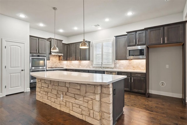 103 Lockhart Loop, Georgetown, TX 78628 - kitchen with appliances with stainless steel finishes, light countertops, dark wood-type flooring, decorative backsplash, and recessed lighting