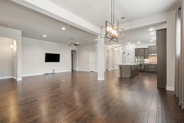 103 Lockhart Loop, Georgetown, TX 78628 - unfurnished living room featuring arched walkways, a ceiling fan, dark wood finished floors, recessed lighting, and baseboards