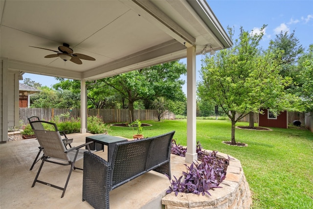view of patio / terrace with a storage shed, a fenced backyard, outdoor dining area, a ceiling fan, and an outdoor structure