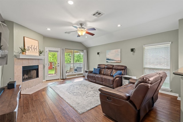 living room featuring a tiled fireplace, a ceiling fan, hardwood / wood-style flooring, and visible vents