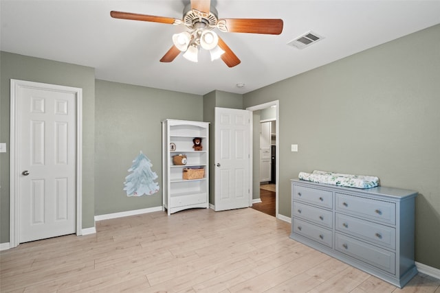 bedroom featuring visible vents, light wood-style flooring, ceiling fan, and baseboards