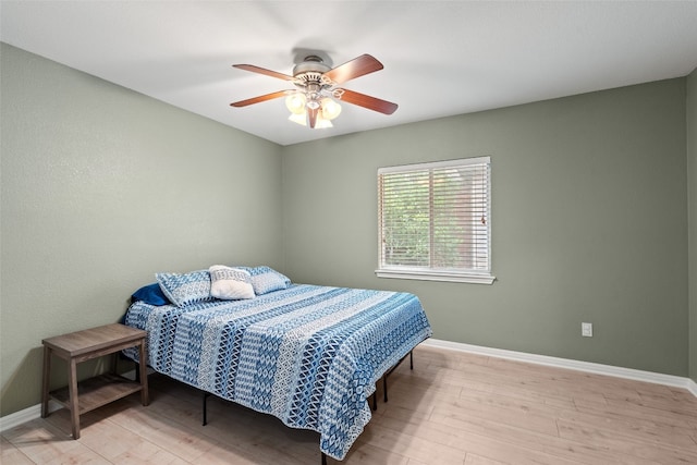 bedroom featuring baseboards, ceiling fan, and wood finished floors