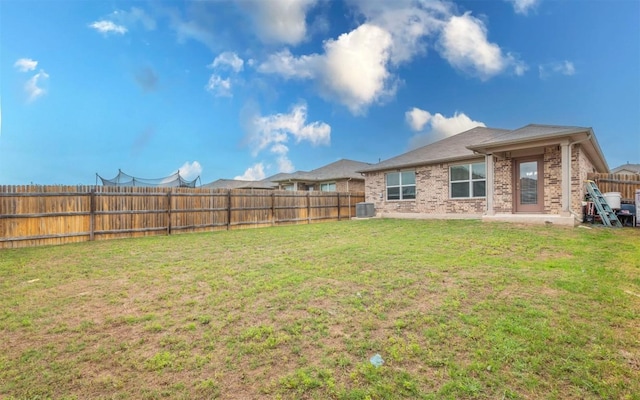 view of yard with central AC unit and a fenced backyard