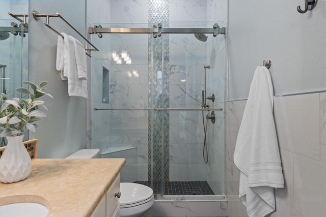 full bathroom with vanity, a stall shower, and toilet