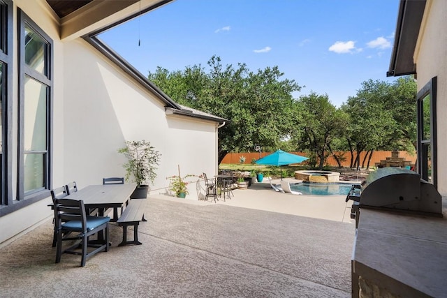 view of patio / terrace featuring outdoor dining area, a fenced backyard, and a pool with connected hot tub